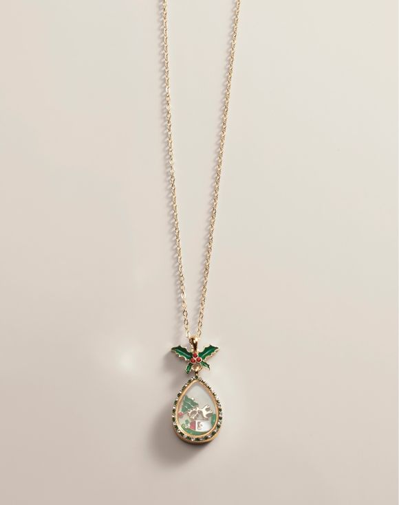 Gold chain necklace featuring a teardrop pendant adorned with holly leaves and a small decorative element inside.