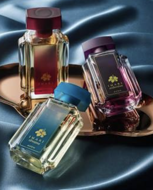 Three elegant perfume bottles arranged on a reflective surface, with a blue, red, and purple top, against a silky blue background.